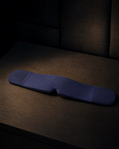 Blue weighted sleep mask isolated against a dark background
