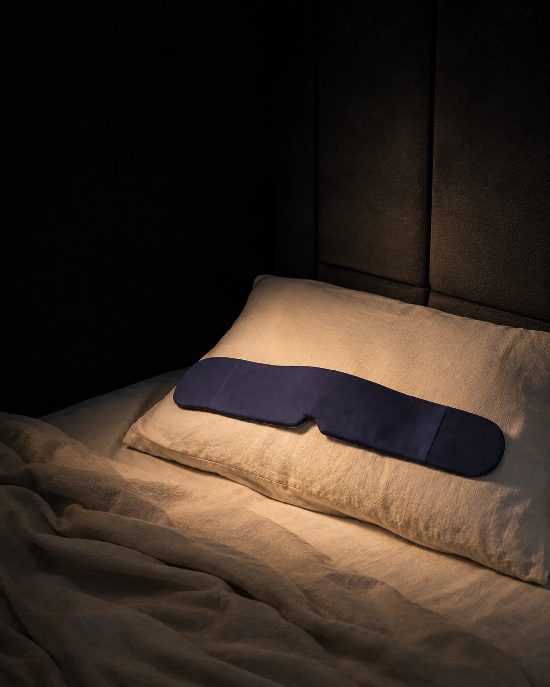 Blue weighted sleep mask shown in a bedroom setting for scale